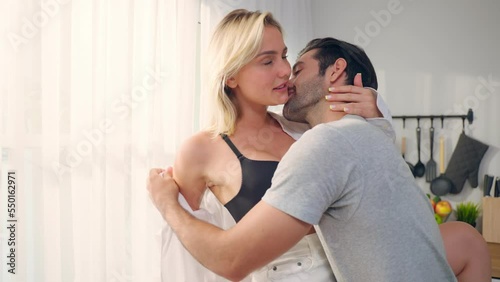 Caucasian young couple starting foreplay and making love in living room.  photo