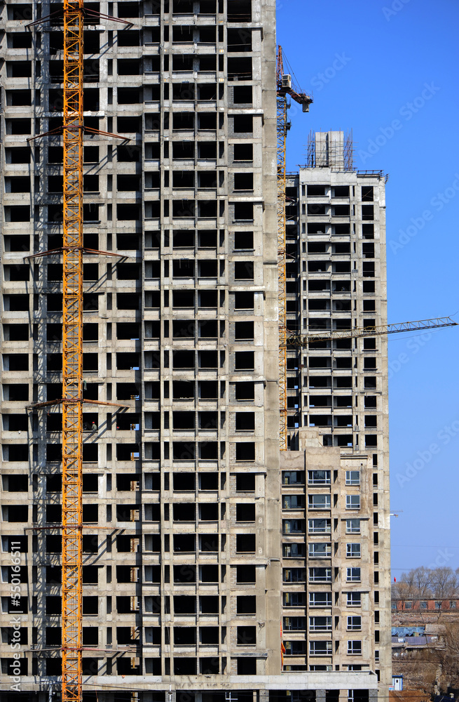 Crane and building construction site against blue sky Crane and building construction site against blue sky