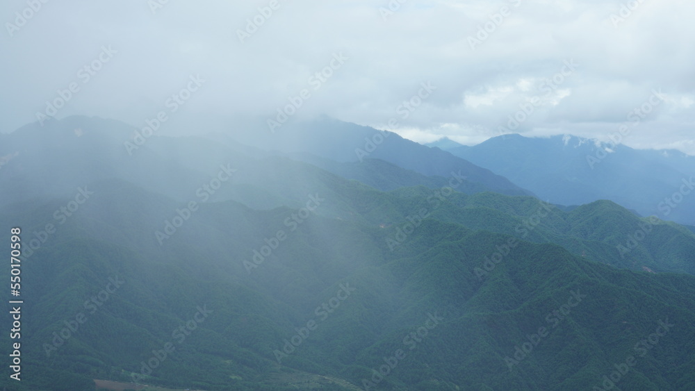 The raining mountains view with the foggy and misty raining droplets