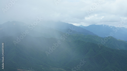 The raining mountains view with the foggy and misty raining droplets © Bo