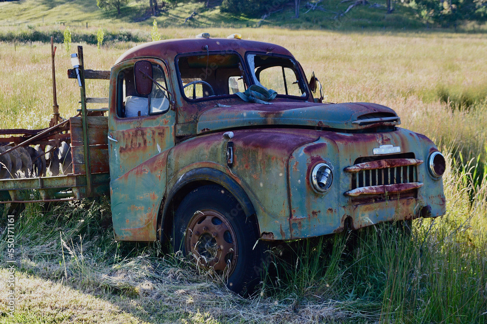 An old car parked in a grassy field