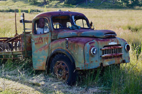 An old car parked in a grassy field