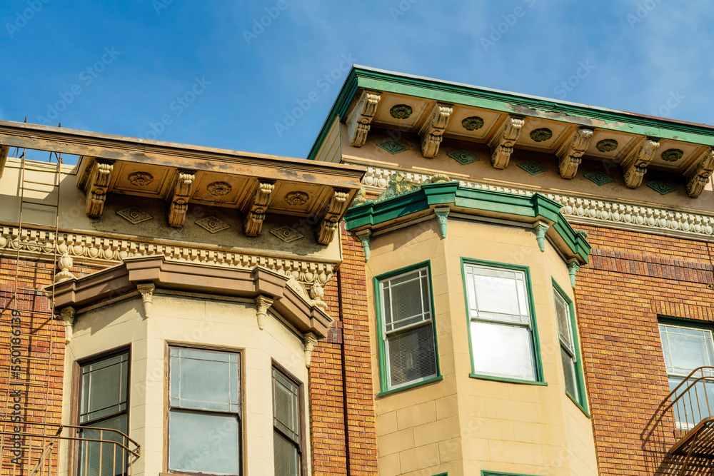 Close up of windows on the exterior of brown stone building in an urban area of the downtown city Close up of windows on the exterior of brown stone building in an urban area of the downtown city