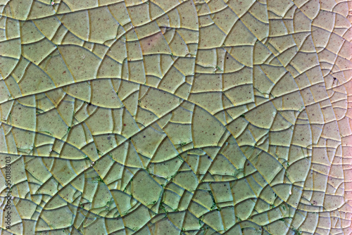 Close up to background and texture of stretch marks cracked on emerald green glazed tile. Scratches background. Vintage scratched grunge tile broken screen texture. Scratched glass surface wallpaper.