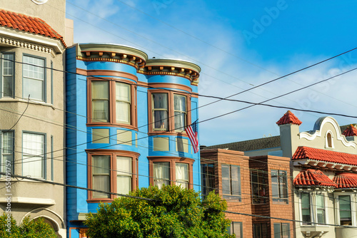 Row of decorative colorful houses with visible powerlines and modern home facades in San Francisco California