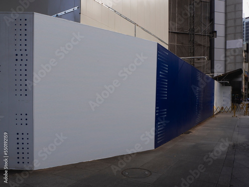 Blank empty construction hoarding space for advertisement mockup. Construction site area in the central business district.