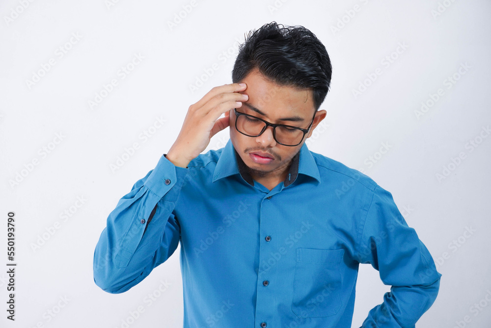 young asian man in wearing blue shirt holding head suffering from headache because migraine and dizzy isolated on white background young asian man in wearing blue shirt holding head suffering from headache because migraine and dizzy isolated on white background