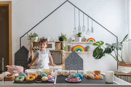 Obraz na plátně Male baby chef in apron posing at childish kitchen cafe public catering food swe