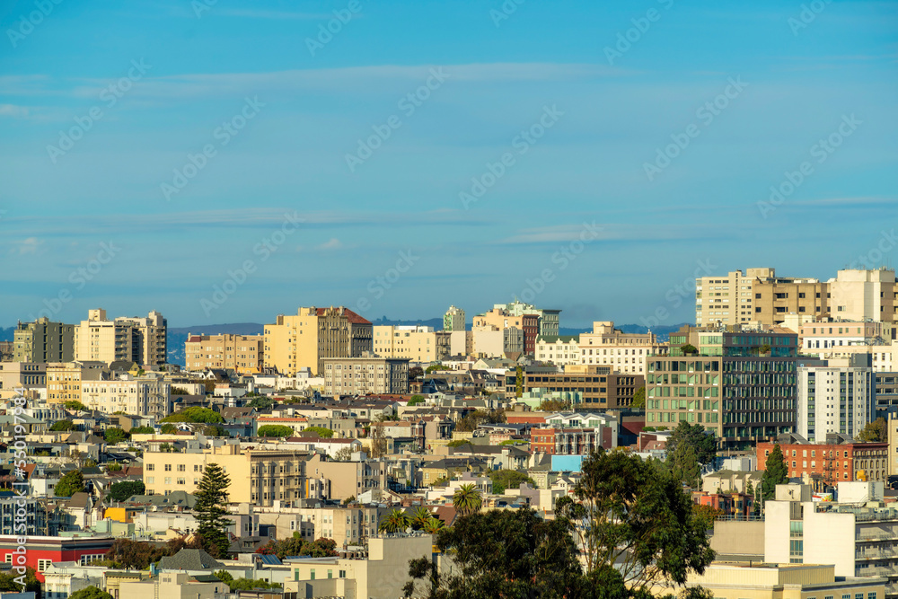 A great many buildings in downtown San Francisco California in a neighborhood with houses and businesses in late afternoon sun