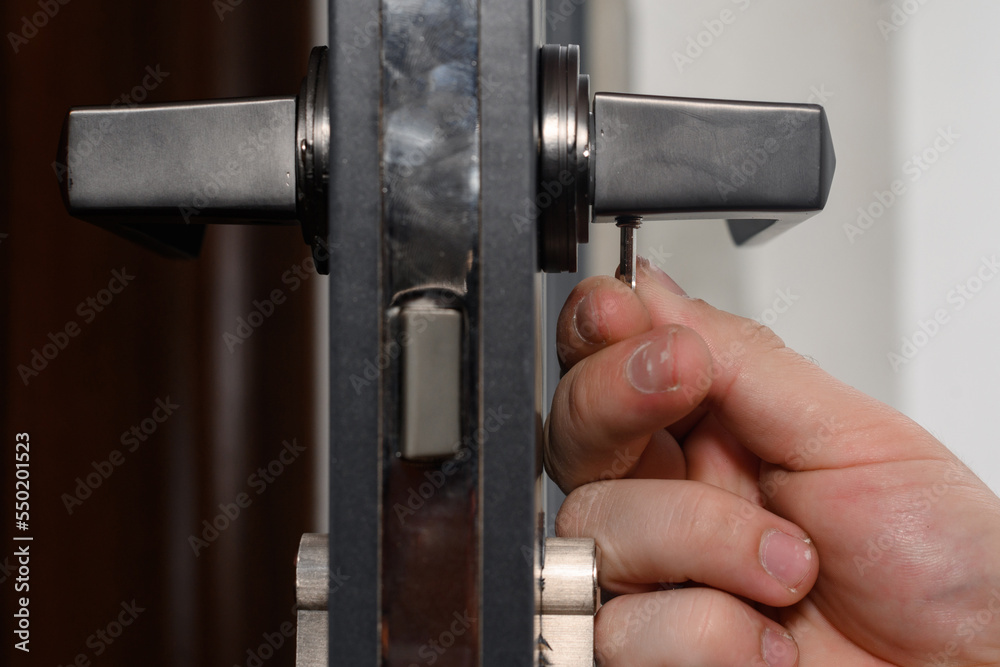 Hex key and installation of door lock and handle, close-up of installation work. Hex key and installation of door lock and handle, close-up of installation work.