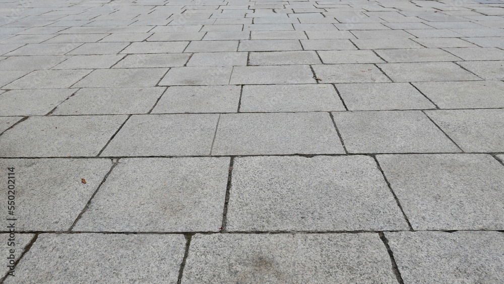 Full frame texture image of grey paving stones leading into the distance