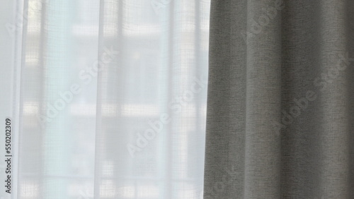 Voile curtain in front of window with grey curtain to side