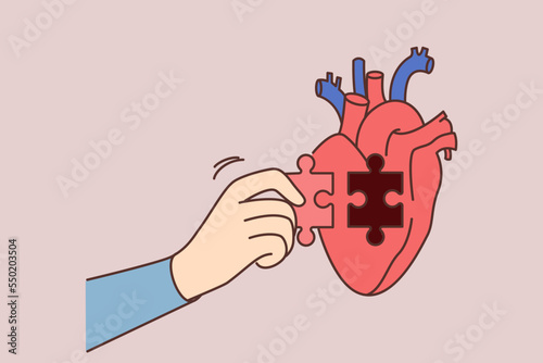 Person hand put puzzle to heart 