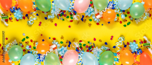 Birthday background top view. Balloons and various party decorations on a yellow background