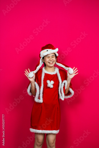 Smiling Asian Woman Posing on an Isolated Red Background With Christmas Attire