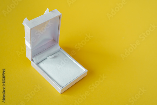 White open gift box isolated on yellow background. Empty jewelry box, place for a gift to birthday or winter holidays.