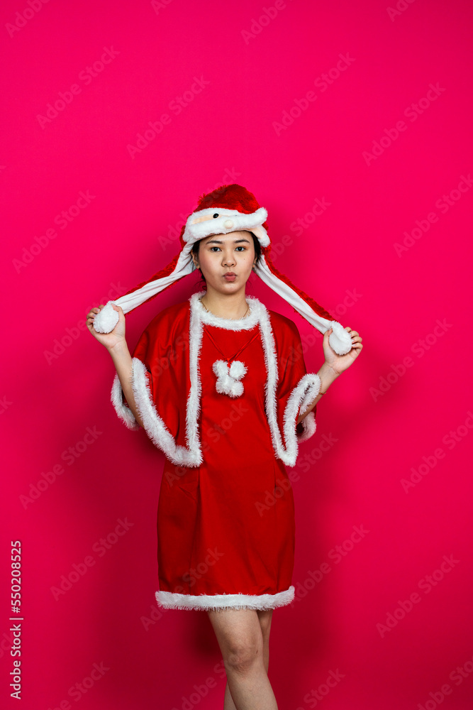 Cute Asian Woman Posing on an Isolated Red Background With Christmas Attire