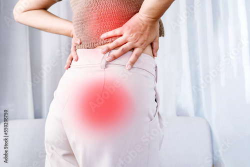 woman suffering from lower back pain spreading to buttocks, Sciatica pain concept photo