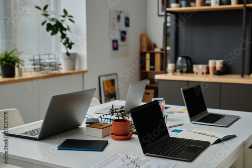 Horizontal image of workplace of office workers with laptop computers for online work at IT office