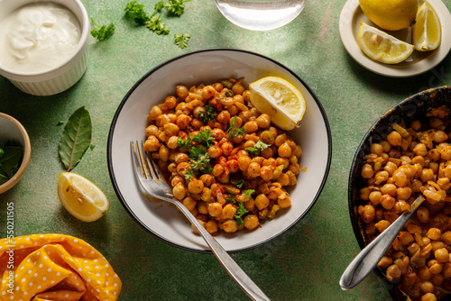 Cooked Chickpea dish with curry and spices, homemade vegan chickpeas, healthy food, colorful green background