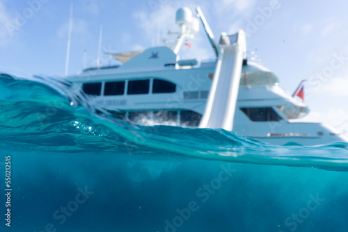 Person splashing in the water after going off waterslide on a superyacht in the Bahamas