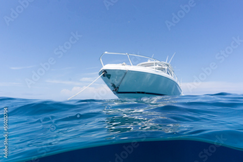 Fototapete luxury boat sitting on anchor, floating in deep blue water with blue sunny skies in background