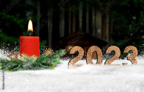 Jahreszahl 2023 aus Holz im Schnee mit Kerze