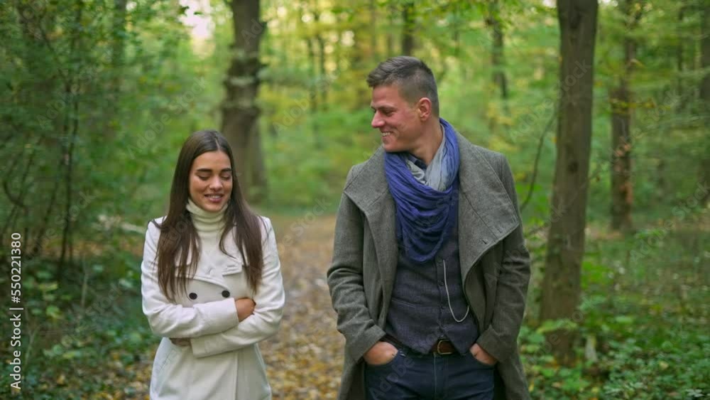 Happy young couple spending time together during pleasant walk in autumn forest. Happy young couple spending time together during pleasant walk in autumn forest.