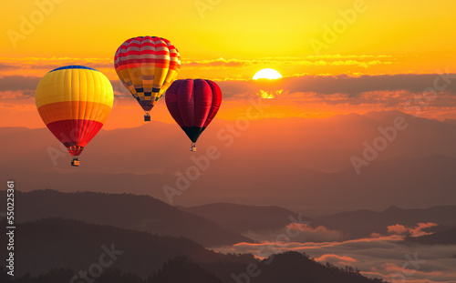 color hot air balloon in sky at sunrise time, Colorful hot-air balloons flying in orange sky and sunset. Sport, adventure, transportation,Travel. © somchairakin