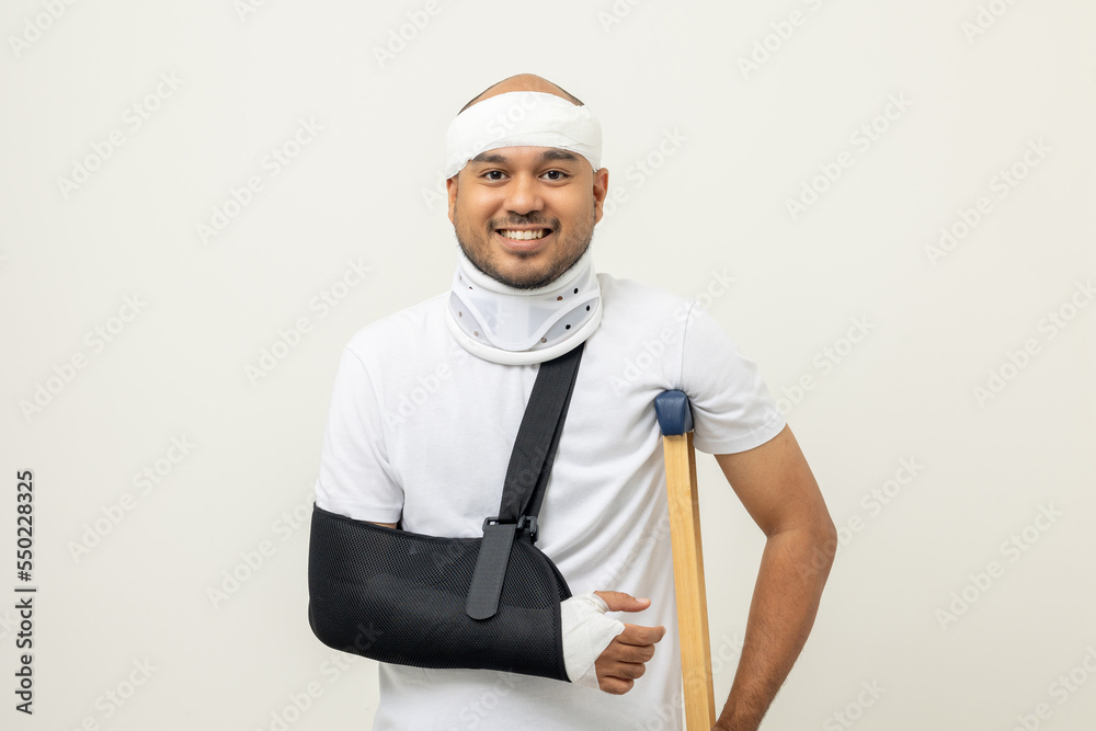 Happy young asian man broken arm and leg on isolated. Man put on plaster cast splint
