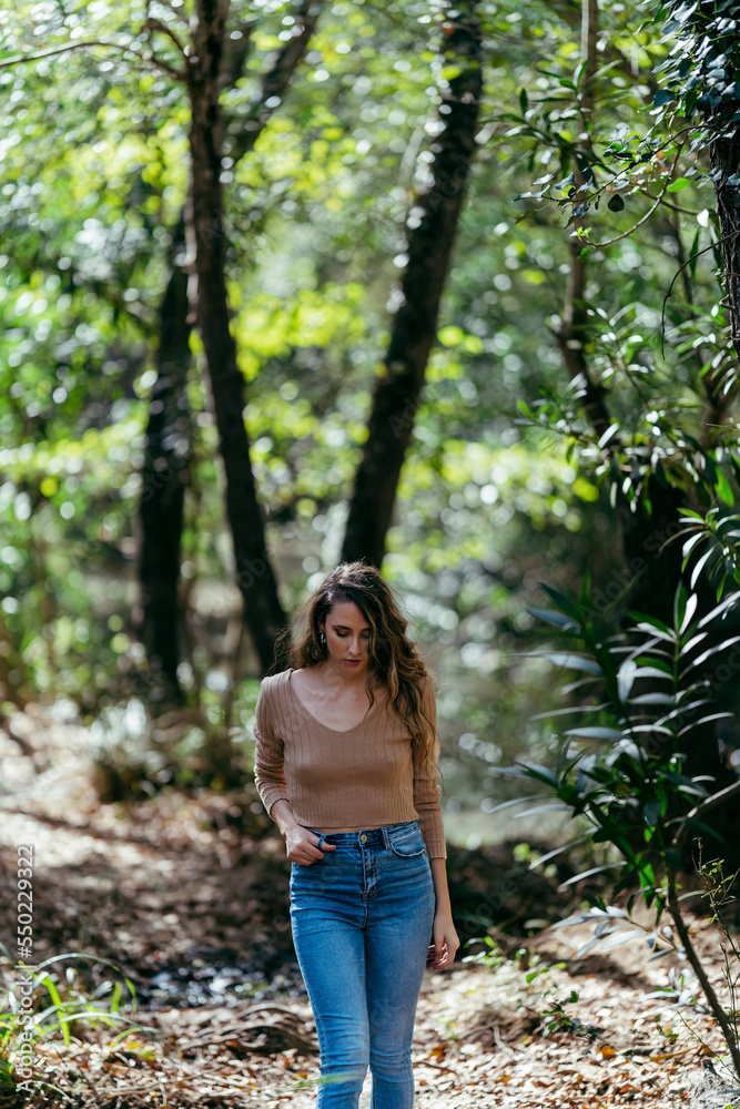 Chica joven delgada caminando por sendero de bosque Chica joven delgada caminando por sendero de bosque