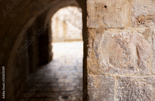 Blurred pedestrian arched tunnel in Old City of Jerusalem  in front of Jerusalem stone column.  Israel.