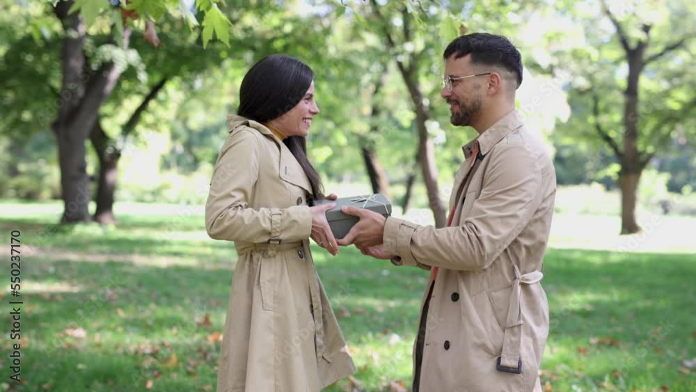 Caucasian boyfriend give box gift to lovely pretty girlfriend in autumn park surprise present for valentine's day birthday anniversary symbol of love affection Caucasian boyfriend give box gift to lovely pretty girlfriend in autumn park surprise present for valentine's day birthday anniversary symbol of love affection