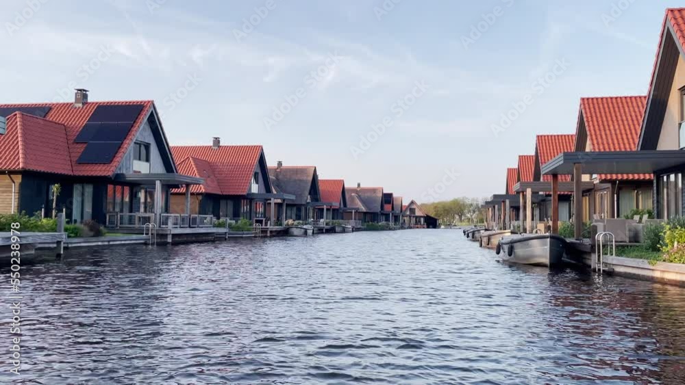 Bungalows At Luxurious Holiday Resort And Polder With Boats On Jetty At Waterstaete Ossenzijl, Netherlands. Aerial Drone Shot Bungalows At Luxurious Holiday Resort And Polder With Boats On Jetty At Waterstaete Ossenzijl, Netherlands. Aerial Drone Shot