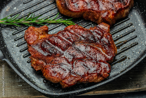 Roasted pork steaks, cutlets with rosemary and spices on a dark background. Restaurant menu, dieting, cookbook recipe top view