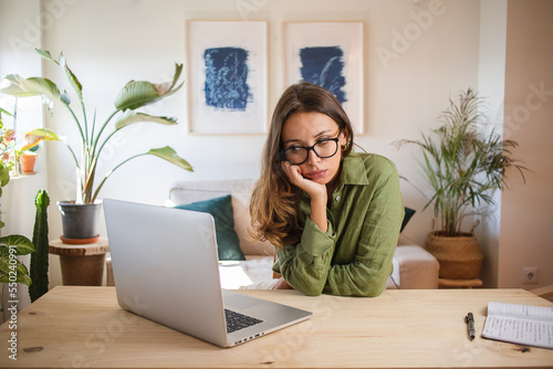 Woman bored and procrastinating working from home
