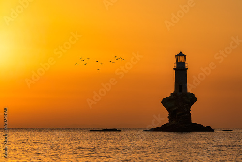 Silhouette of the lonely Tourlitis light house during sunrise at the Greek island of Andros, Cyclades