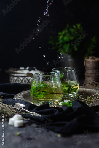 herbal, mint tea with splashes on a dark background