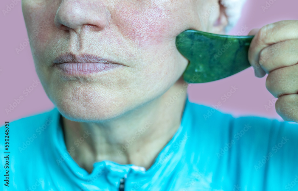elder senior lady after 50 years old woman doing facial massage gua sha