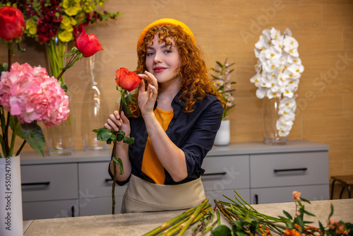 Young ginger girl in beret in a flower shop photo