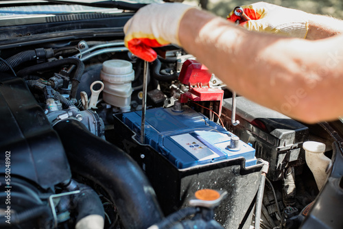 man changes a car battery. Car repair and maintenance