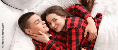 Morning of happy young couple in Christmas pajamas