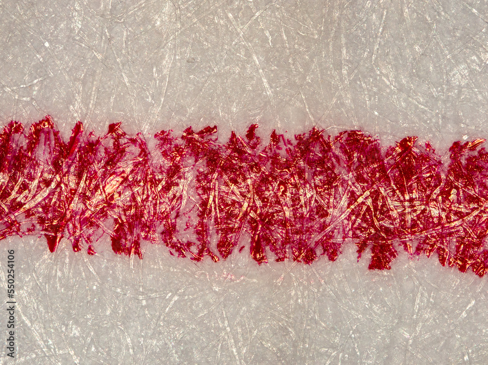red ballpoint pen stroke on a sheet of paper under the microscope