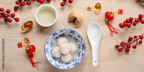 Bowl of tangyuan, cup of tea and Chinese decor on wooden background. Dongzhi Festival