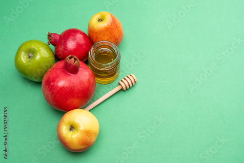 Jewish New Year Rosh Hashanah Traditional green background with colorful apples, pomegranate and honey