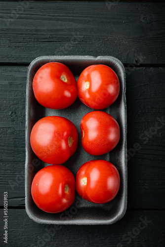Red ripe tomatoe, on black wooden table