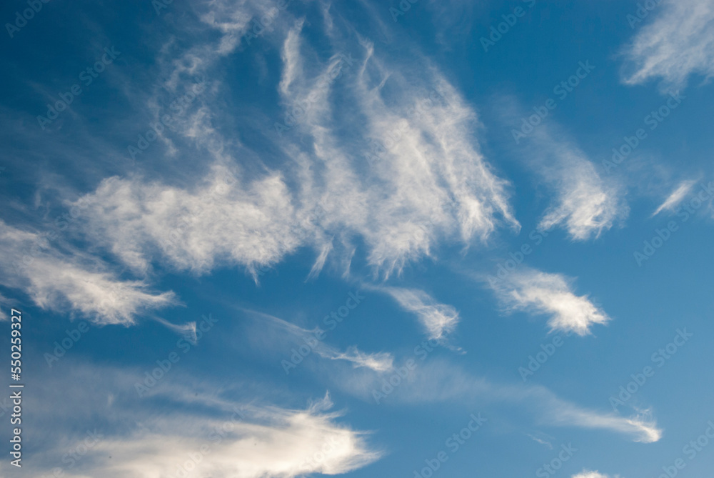 Obraz premium Whispy white clouds against blue sky in daylight