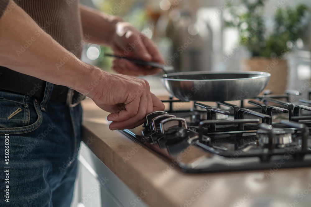 Man standing near the stove and frying something Man standing near the stove and frying something