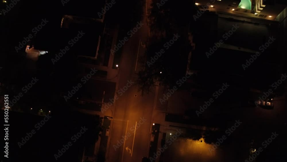 Ascending shot of a car driving along the street at midnight Ascending shot of a car driving along the street at midnight
