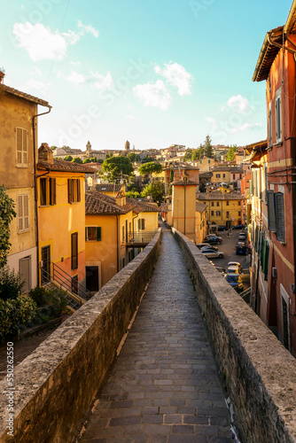 Italian Aqueduct Street, with houses and trees on both sides. In front is the view of the city, on the lower right there is a parking lot with the cars. © Siarhei